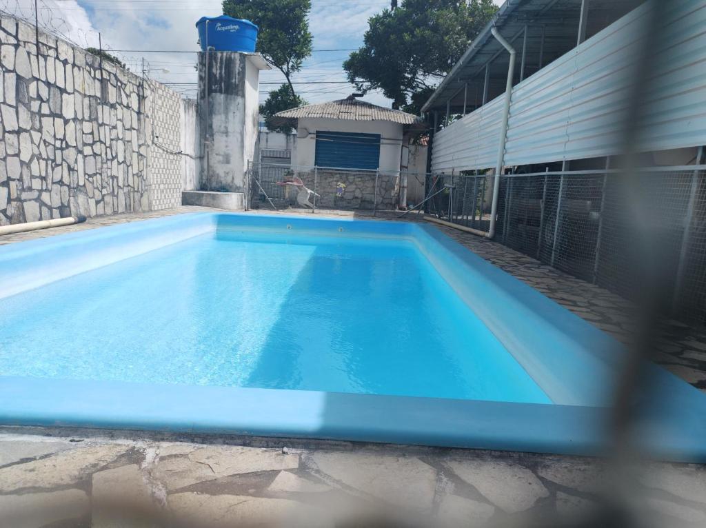 una gran piscina azul en el patio trasero en Casa encantadora em João pessoa, en João Pessoa