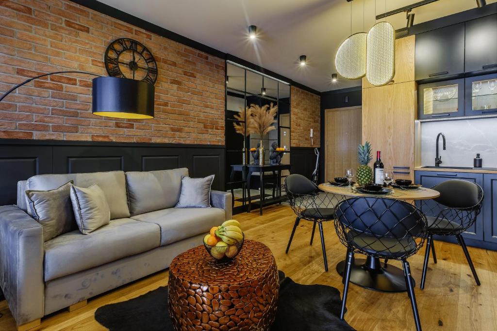 a living room with a couch and a table at APARTAMENT CHICAGO - stylowy apartament o bardzo wysokim standardzie w centrum miasta, z prywatnym zadaszonym parkingiem - IZBY PODHALAŃSKIE in Nowy Targ