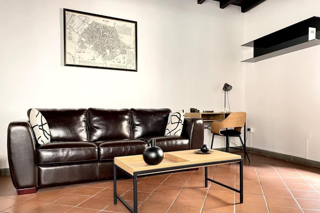 ein Wohnzimmer mit einem Ledersofa und einem Tisch in der Unterkunft Wonderful central apartment! in Mantua