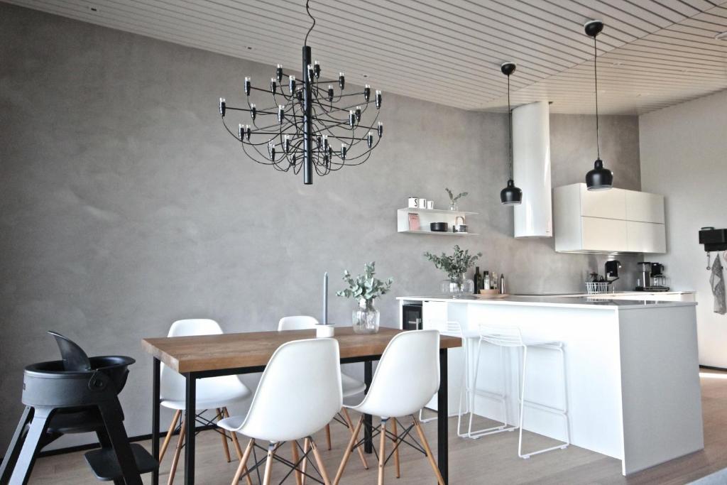 a dining room with a table and white chairs at Arctic Riverside Villa in Rovaniemi