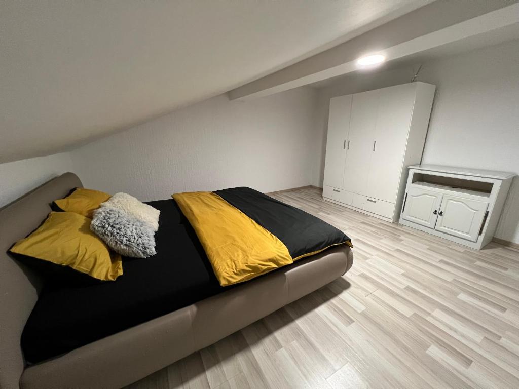 a bedroom with a bed with yellow and black sheets at Golden House in Osijek