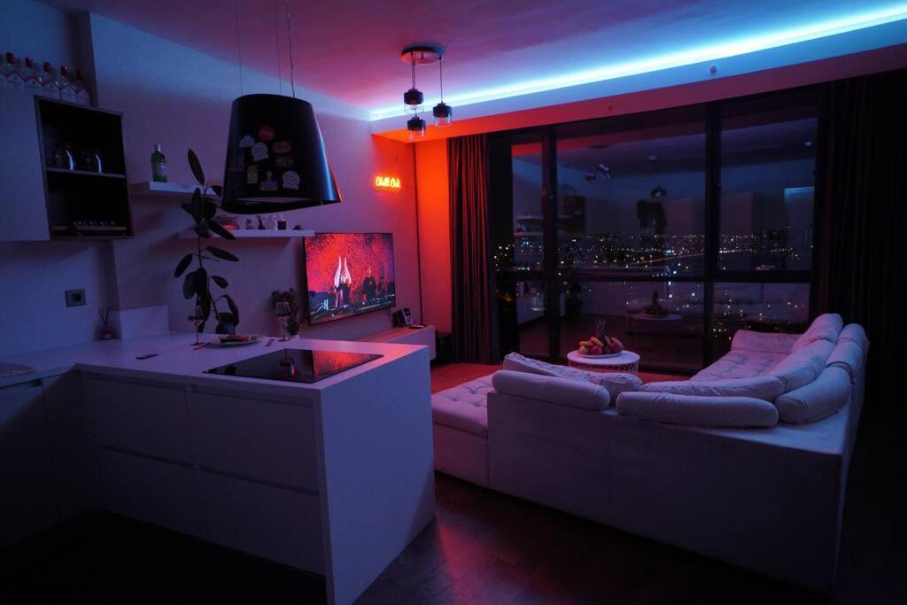 una cocina con fregadero y un sofá en una habitación en Lux Residance 40th floor, sound system, 65 inch TV, en Ankara