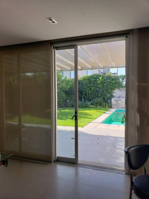 una puerta corredera de cristal abierta con vistas a la piscina en Casa Feliz en San Fernando del Valle de Catamarca