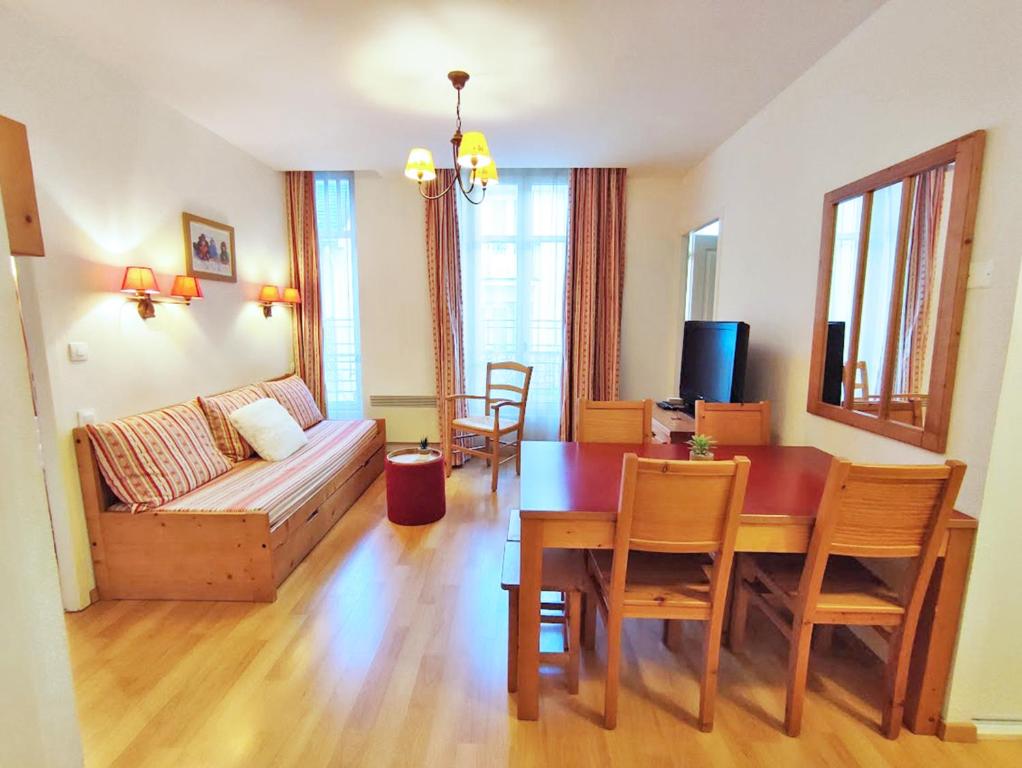 een woonkamer met een bank en een eettafel bij L'Eterlou, T3, centre Luchon, wifi, casier à skis, 6 personnes in Luchon