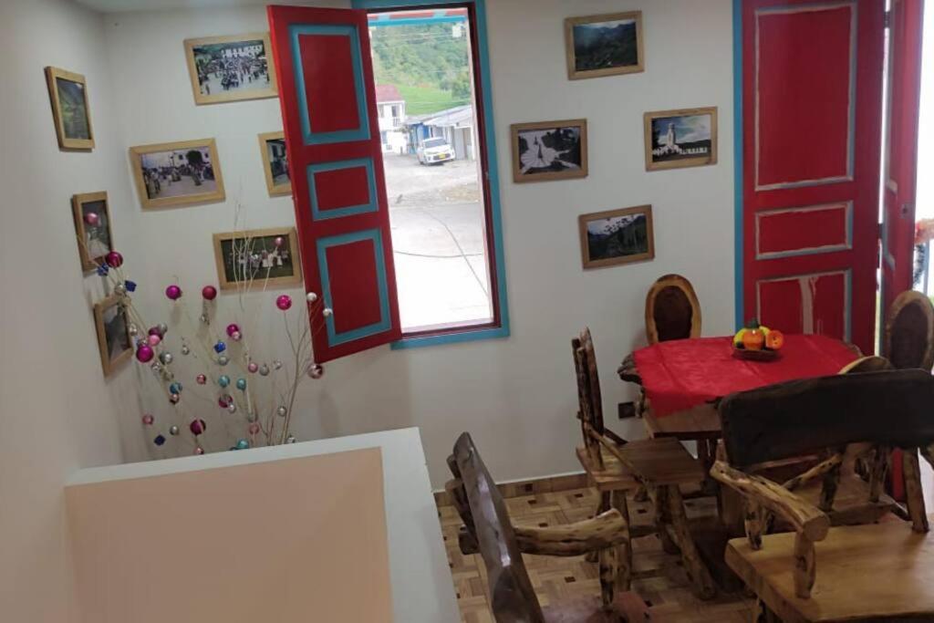 une salle à manger avec une table et des chaises rouges dans l'établissement viviendas turísticas Sara Angel R2, à Salento