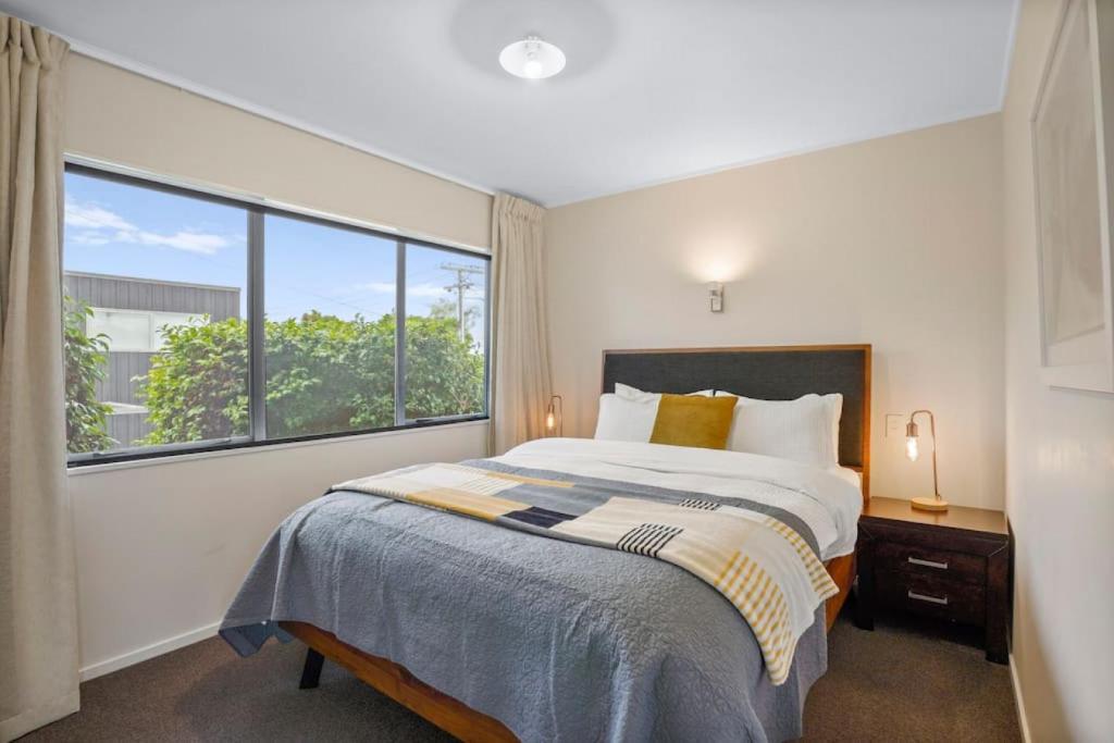 a bedroom with a bed and a large window at Gorgeous 2BR Central Akl Retreat - WI-FI - Netflix in Auckland