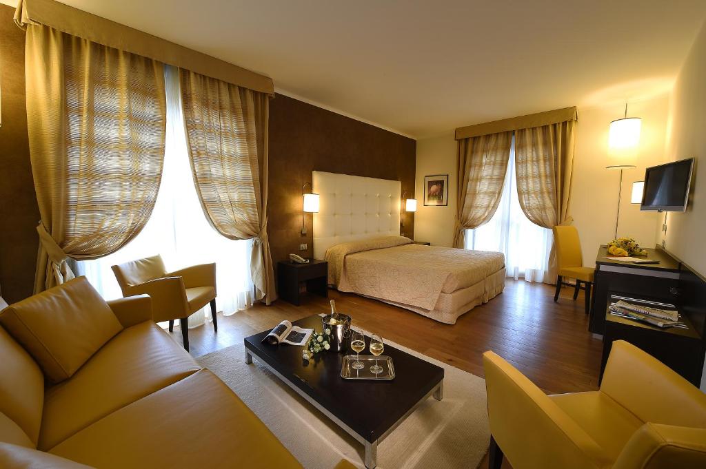 una camera d'albergo con letto e soggiorno di Hotel Rioverde a Pralormo