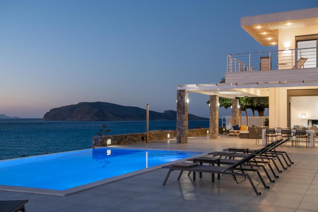 a villa with a swimming pool at night at Haven Villa in Ierápetra