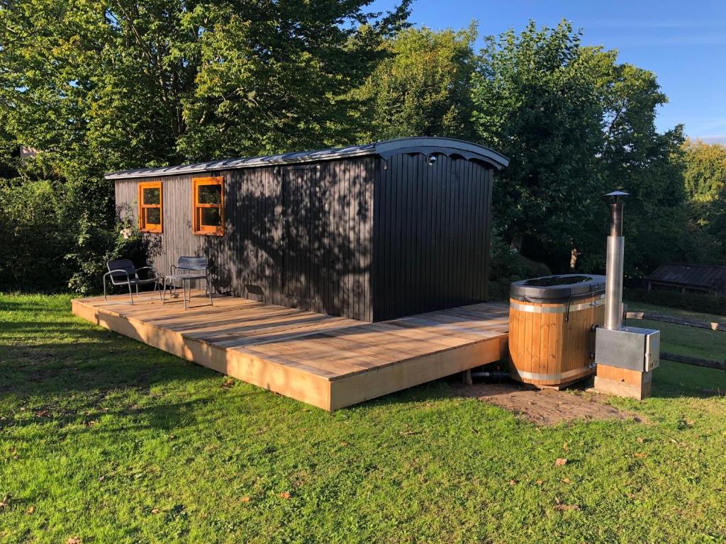 a tiny house with a deck and a trash can at Cool de Sources in La Hulpe