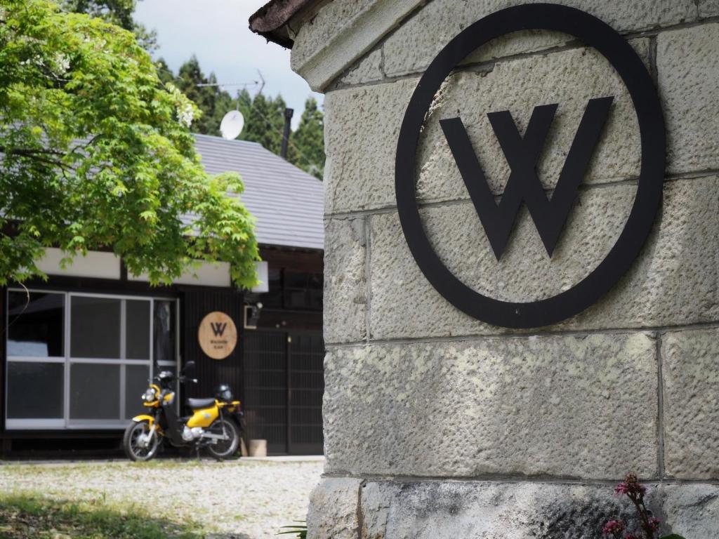 a w sign on the side of a building with a motorcycle at Kominka Washinkan - Vacation STAY 13791 in Yaita