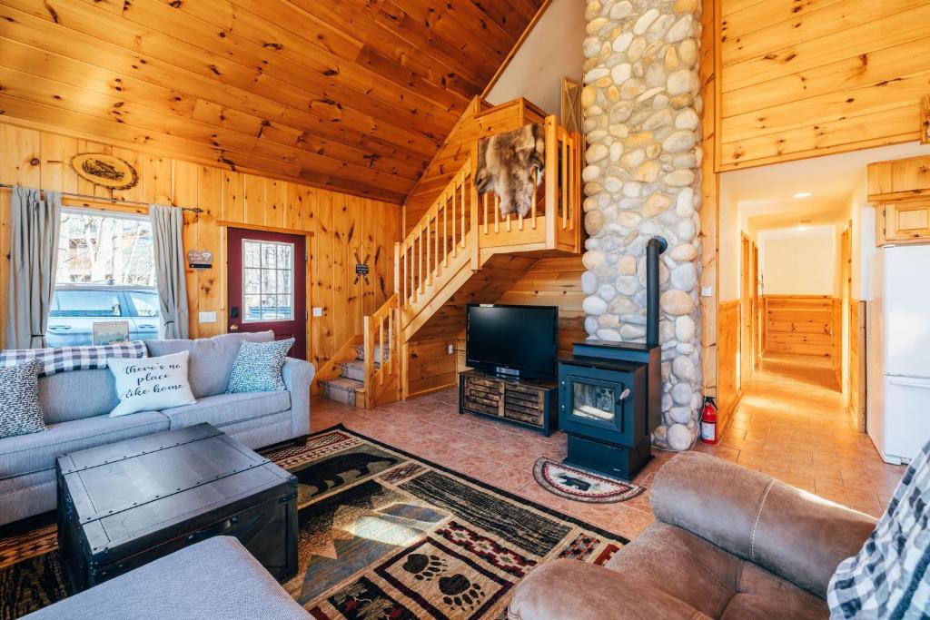 ein Wohnzimmer mit einem Sofa und einem Herd in der Unterkunft Mountain Chalet, Only 3 min to Sunday River ski lifts! in Bethel