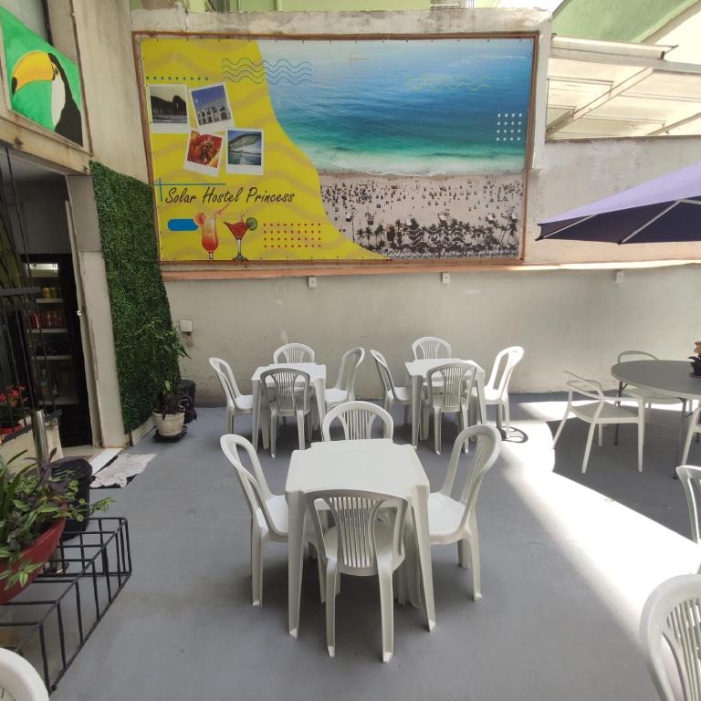 a dining room with white tables and white chairs at Hostel Princess Copacabana in Rio de Janeiro
