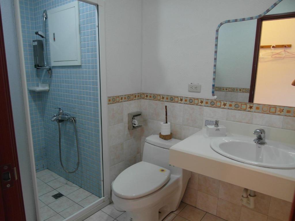 a bathroom with a toilet and a sink and a shower at Morpheus B&amp;B in Kenting