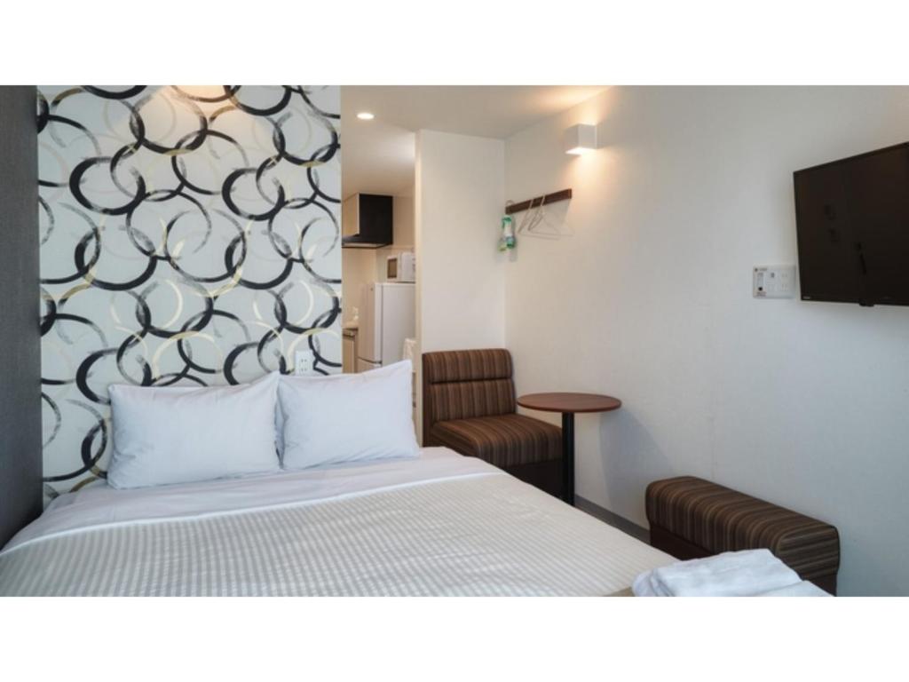 Habitación de hotel con cama y silla en BiBi Hotel Kokusai Dori - Vacation STAY 10008v, en Naha