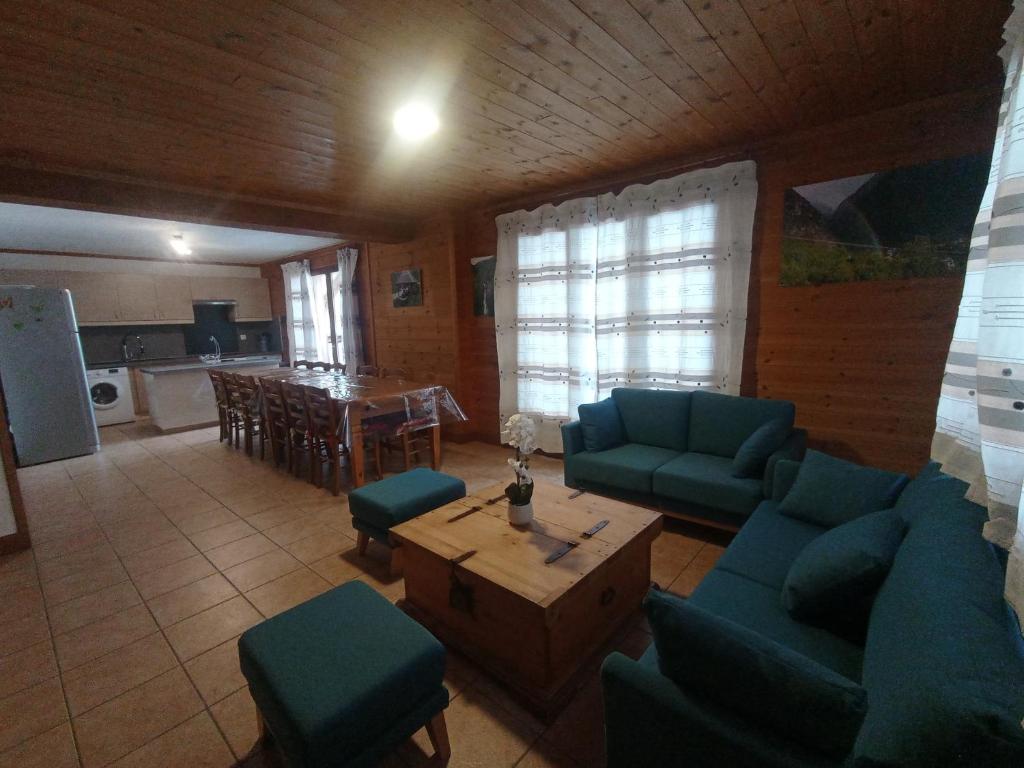 ein Wohnzimmer mit blauen Sofas und einem Tisch in der Unterkunft Chalet les Alpes - Le Sapey in Vénosc