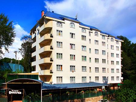 um grande edifício branco com um telhado azul em Imperia Hotel em Sochi