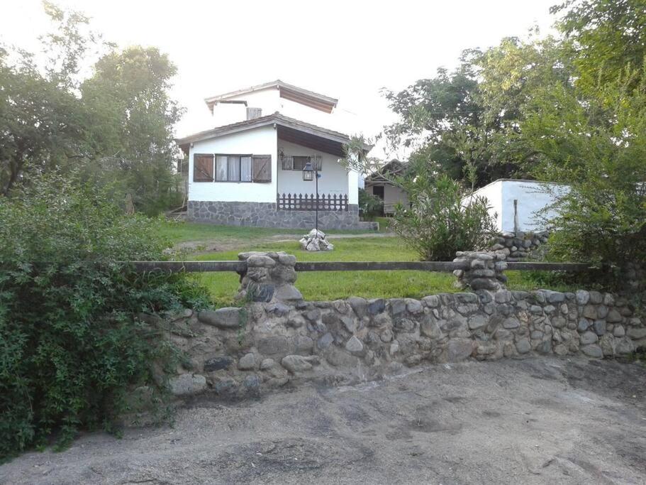 una cerca de piedra frente a una casa en Alquilo Casa en Tanti in 