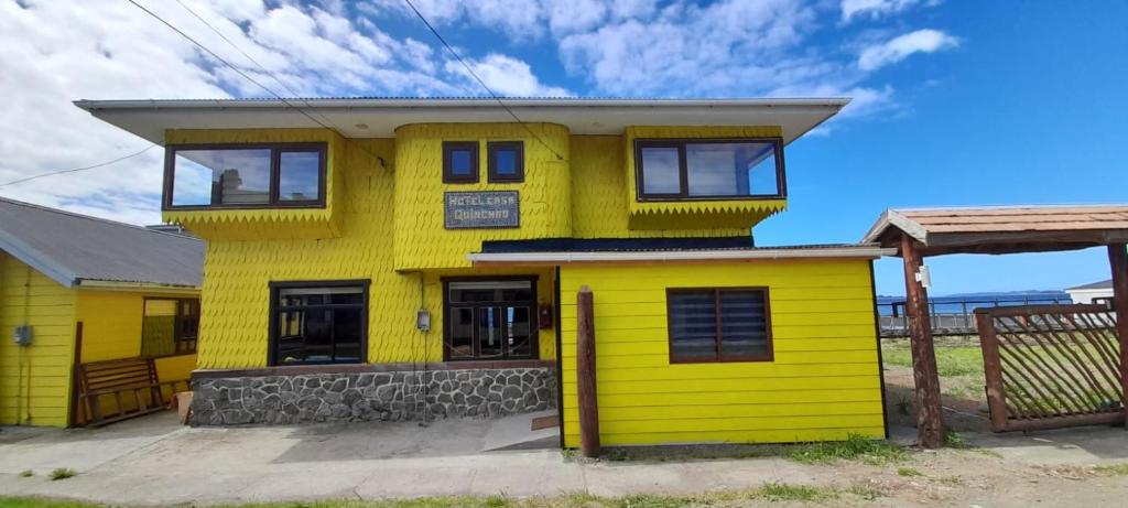 una casa amarilla con techo blanco en Hotel CasaQuinchao, en Achao