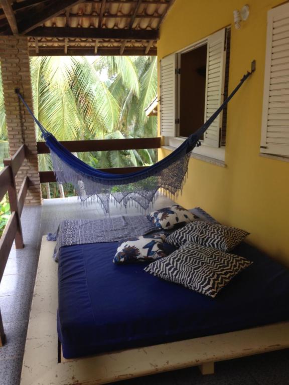 a hammock in a room with a bed at Pousada Familiar e Domiciliar - Perto do Aeroporto de Salvador in Lauro de Freitas