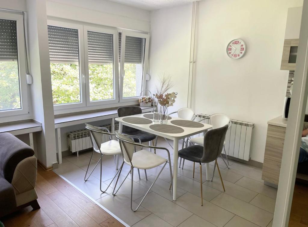 a dining room with a white table and chairs at At the heart of Plitvice Lakes - Self check-in! in Plitvička Jezera