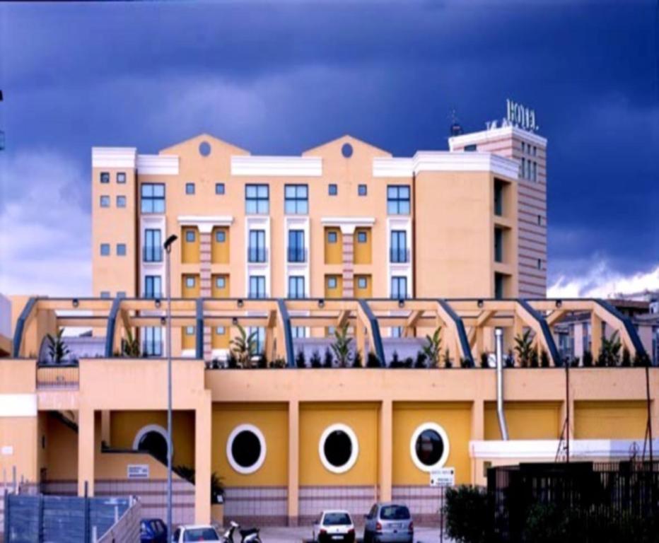 ein großes Gebäude mit davor geparkt in der Unterkunft Hotel Apan in Reggio di Calabria