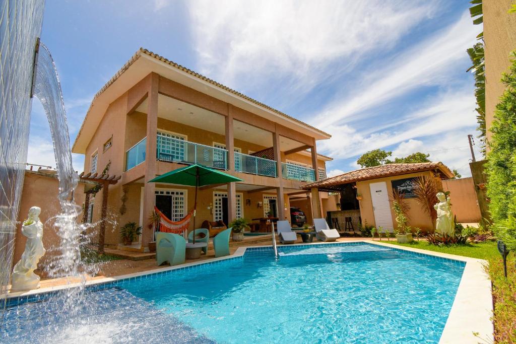uma casa com piscina e uma fonte em Casa de Praia Pouso das Fadas com Arrumadeira e Equipe de Cozinha em Maragogi
