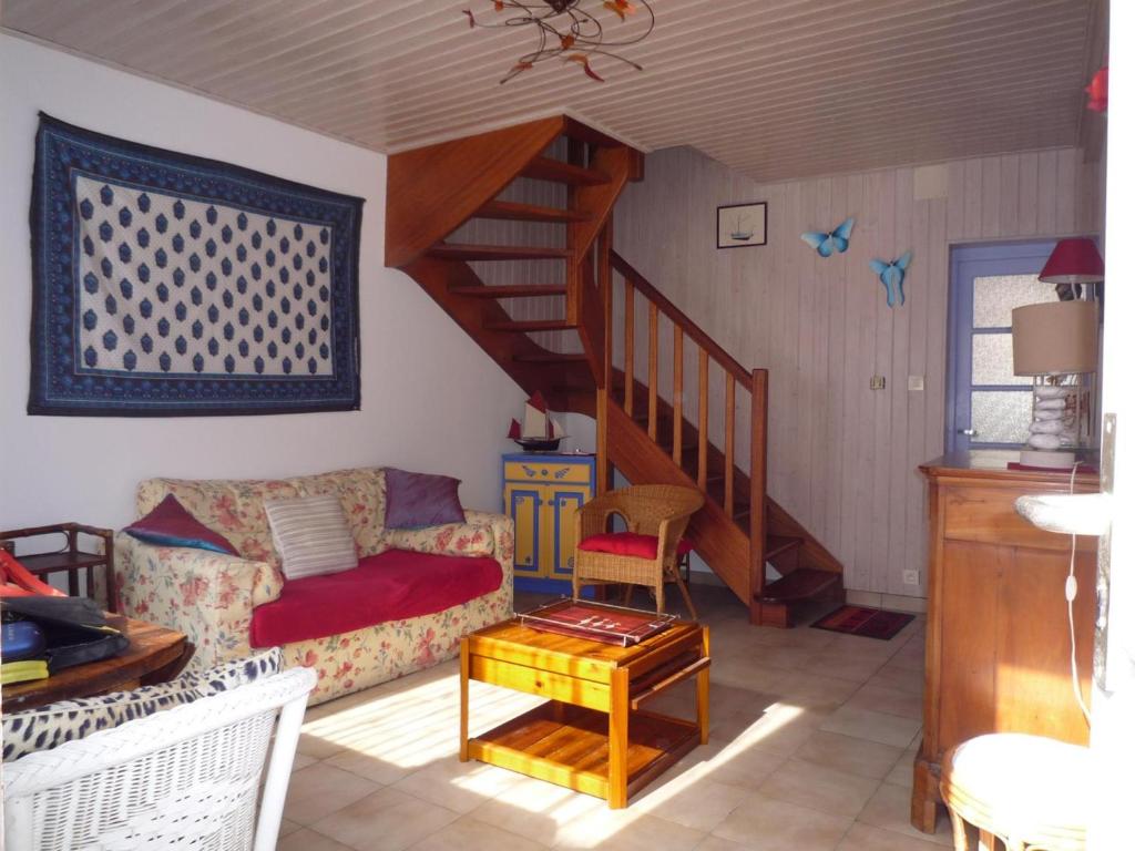 ein Wohnzimmer mit einem Sofa und einer Treppe in der Unterkunft Maison Les Sables-d'Olonne, 3 pièces, 4 personnes - FR-1-92-702 in Les Sables-dʼOlonne