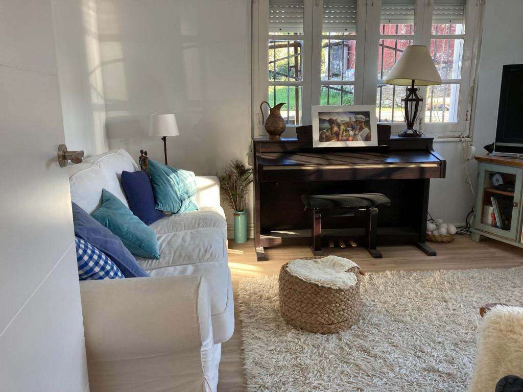 a living room with a white couch and a piano at Maria La Franca in La Franca