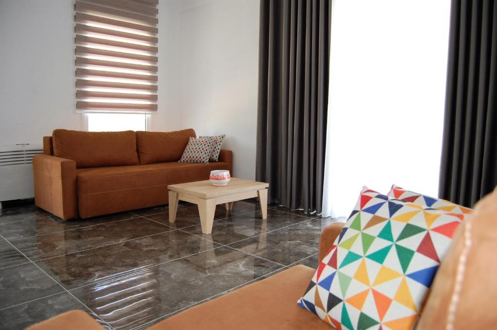ein Wohnzimmer mit Sofa und Tisch in der Unterkunft Era Palace Apartments in Vlorë