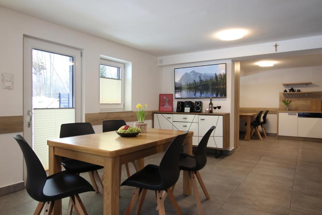 a kitchen and dining room with a table and chairs at Willa na Plażowej in Węgierska Górka