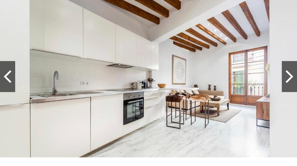 a kitchen with white cabinets and a table and chairs at Hotel-Apartment Modern Studio in Palma de Mallorca
