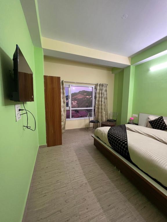 a bedroom with a bed and a flat screen tv at Wonder View in Shimla
