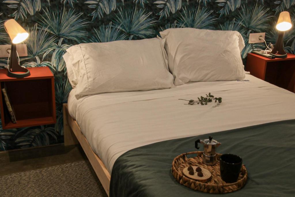 uma cama com lençóis brancos e uma bandeja em Apartamentos Abadía. em Corella