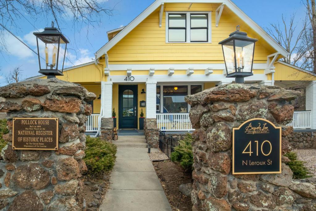 une maison jaune avec un panneau devant elle dans l'établissement Bespoke Inn Flagstaff, à Flagstaff