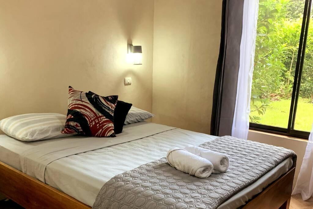 a bedroom with a bed with pillows and a window at Miniapartamento el Guanacaste, cerca Tamarindo in Santa Cruz