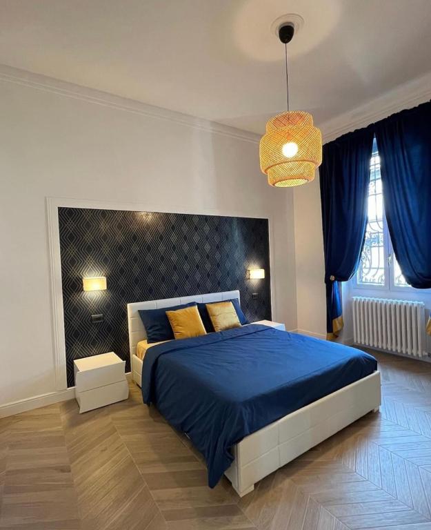 ミラノにあるIsola suitesのベッドルーム(青いベッド1台、シャンデリア付)