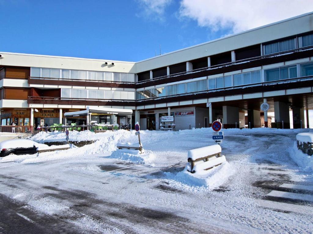 a parking lot covered in snow in front of a building at Appartement Chamrousse, 2 pièces, 6 personnes - FR-1-549-49 in Chamrousse