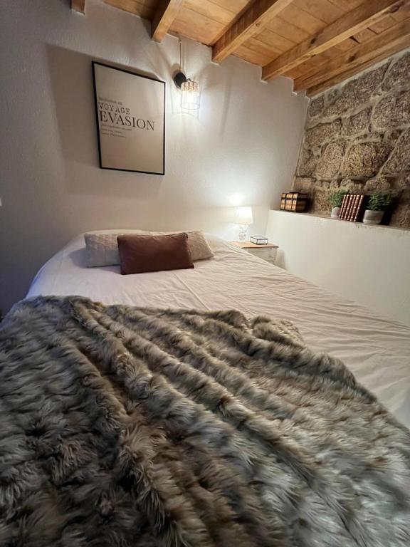 a bedroom with a large bed with a blanket at Stairway to Castle- Monsanto in Monsanto