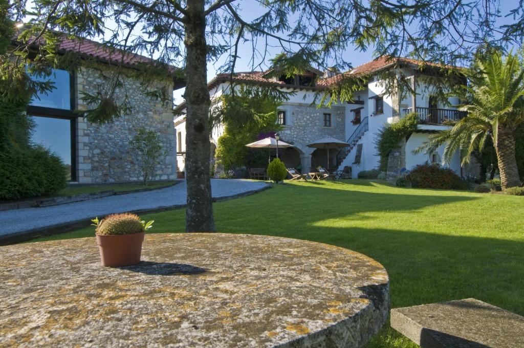 une plante en pot assise sur une table devant une maison dans l'établissement La Casona de Suesa, à Suesa