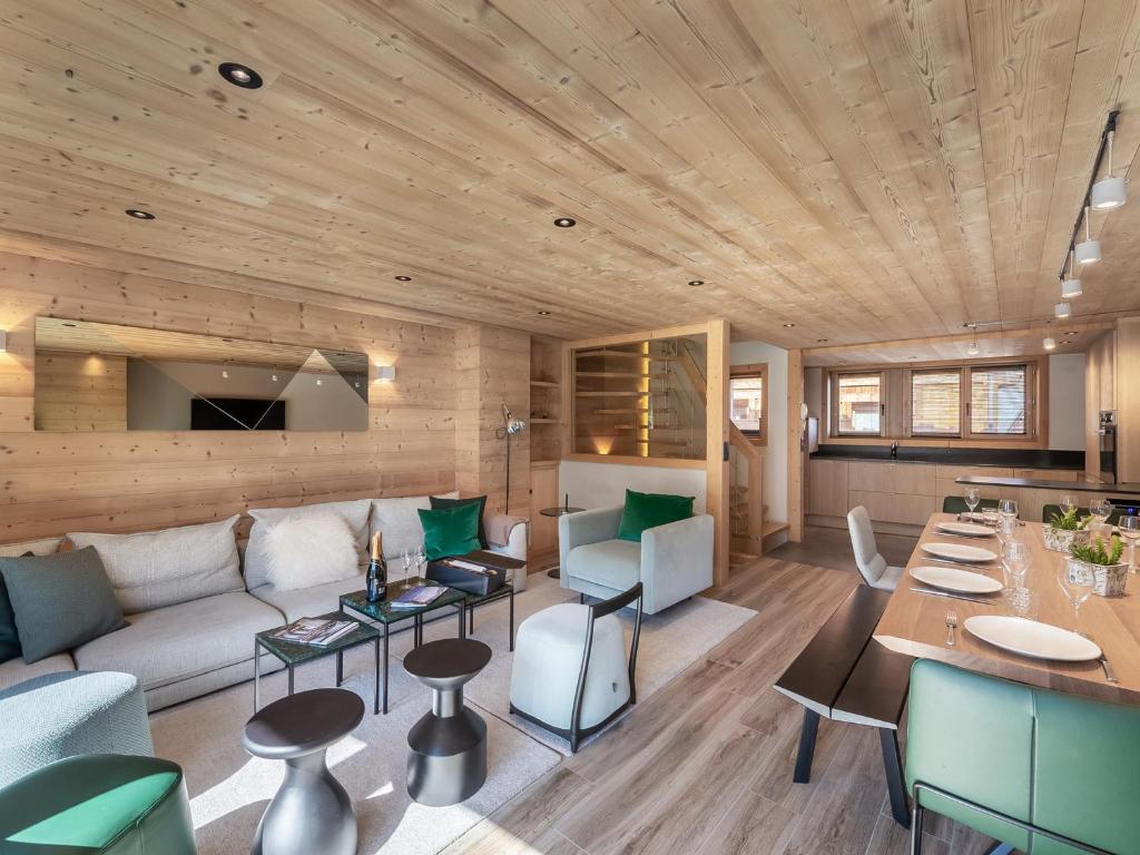 ein Wohnzimmer mit Sofa und Tisch in der Unterkunft Chalet moderne à Méribel avec 5 chambres, sauna et accès rapide aux pistes - FR-1-566-45 in Les Allues