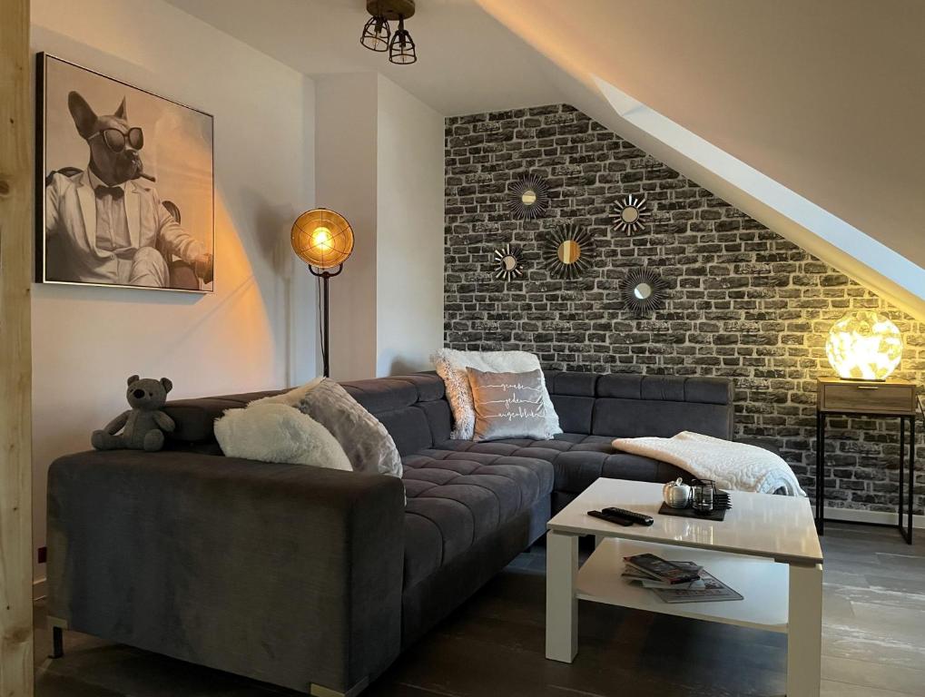 uma sala de estar com um sofá azul e uma parede de tijolos em Appartement DOM II - Erfurt Domplatz em Erfurt