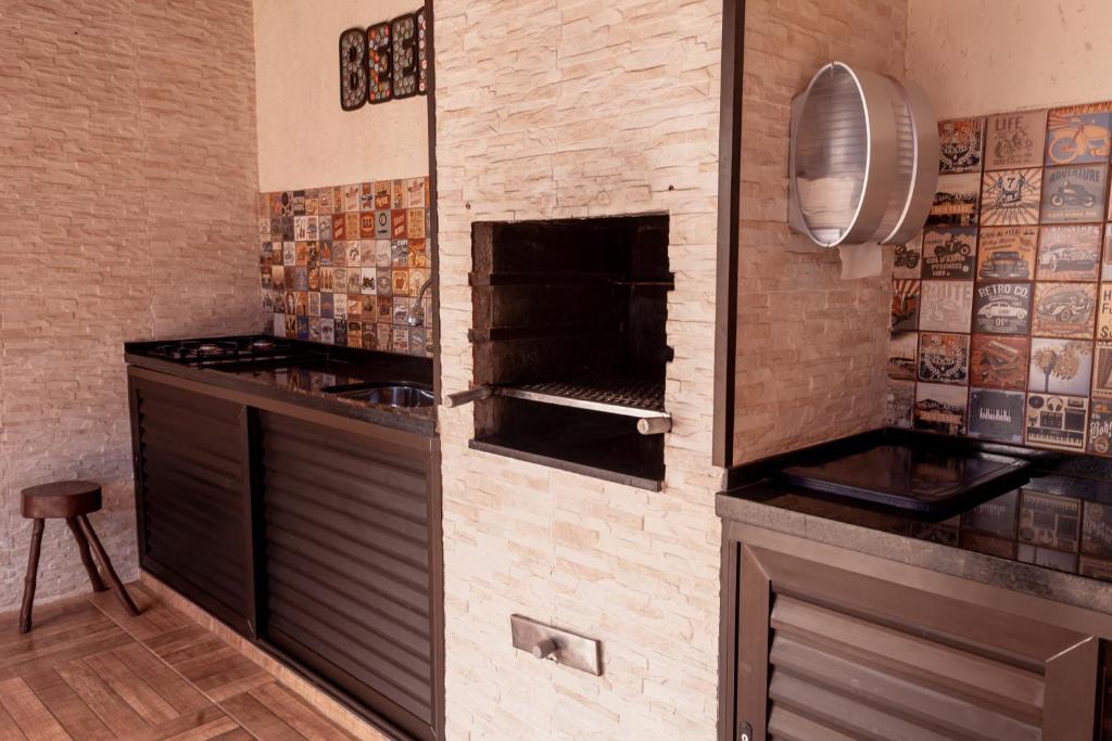 a kitchen with a brick wall with an oven at Pousada Canto Azul Guarujá in Guarujá