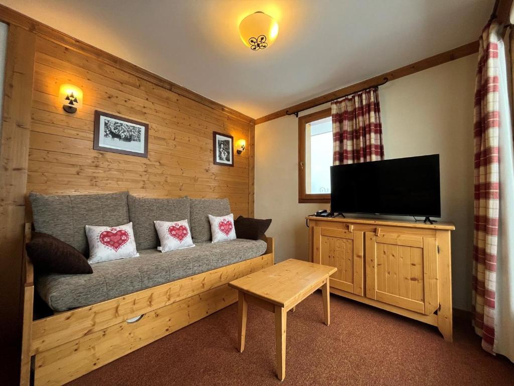 a living room with a couch and a flat screen tv at Appartement Lanslebourg-Mont-Cenis, 3 pièces, 6 personnes - FR-1-508-256 in Lanslebourg-Mont-Cenis