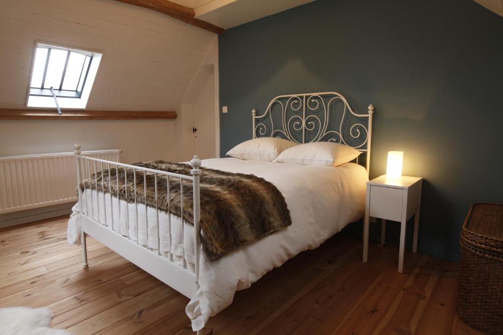 a bedroom with a large bed with a metal headboard at De Sneppelhoeve in Wuustwezel