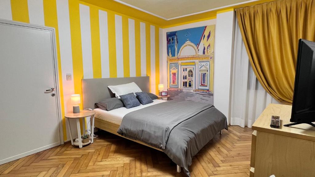 1 dormitorio con 1 cama con rayas amarillas y blancas en Behind On The Canalside Venice, en Venecia
