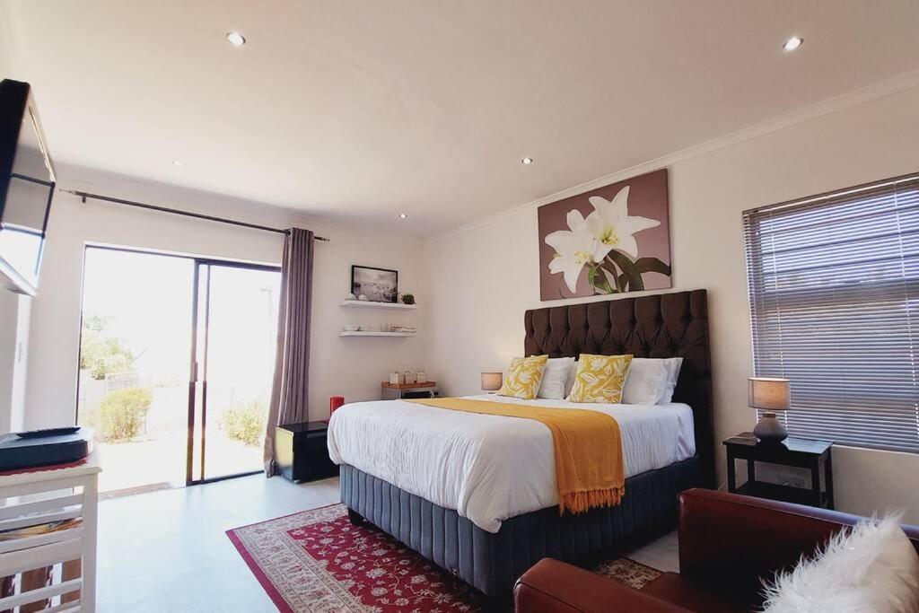 Un dormitorio con una cama grande y una ventana grande. en Cosy Nest - Uncapped Wi-fi & Self Check-in, en Ciudad del Cabo