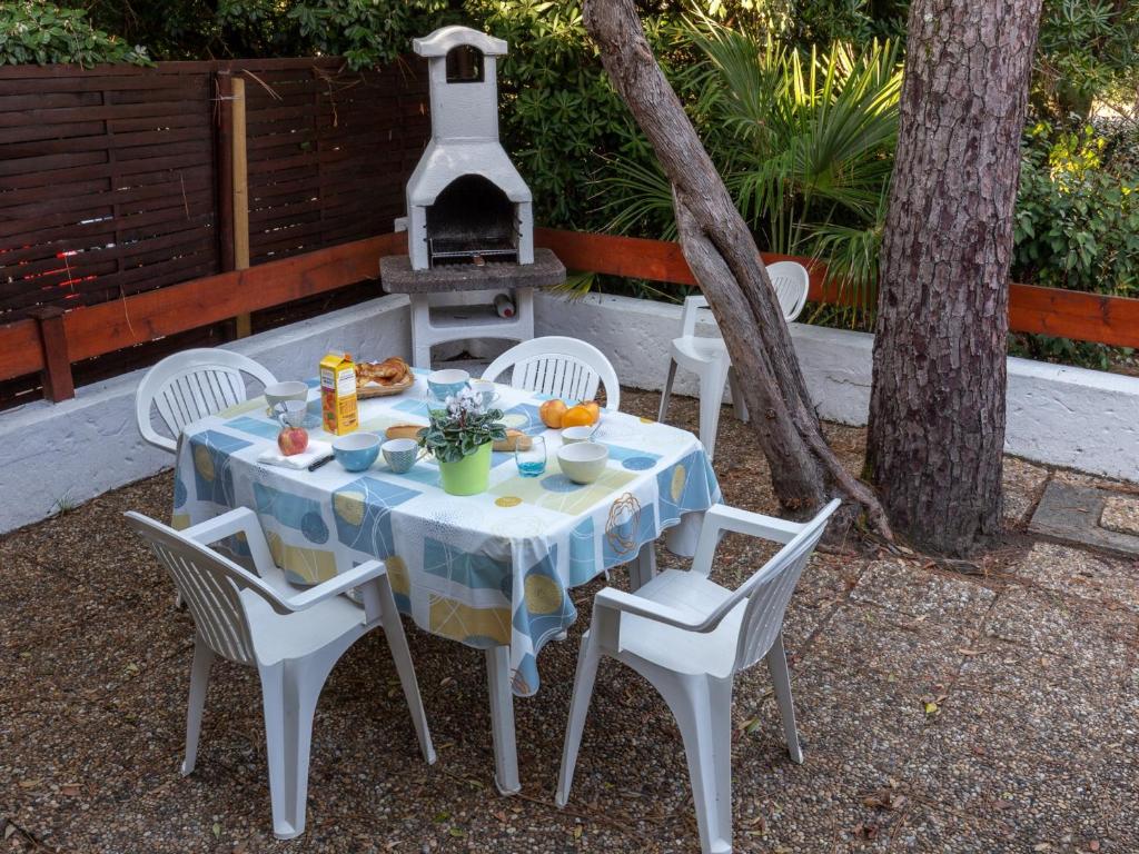 a table and chairs with a table and a grill at Maison Seignosse, 1 pièce, 5 personnes - FR-1-239-394 in Seignosse