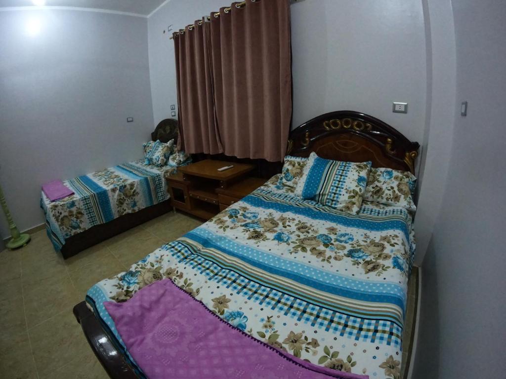 Cozy Apartment Freedom في الغردقة: غرفة نوم مع سرير مع اللوح الأمامي الخشبي