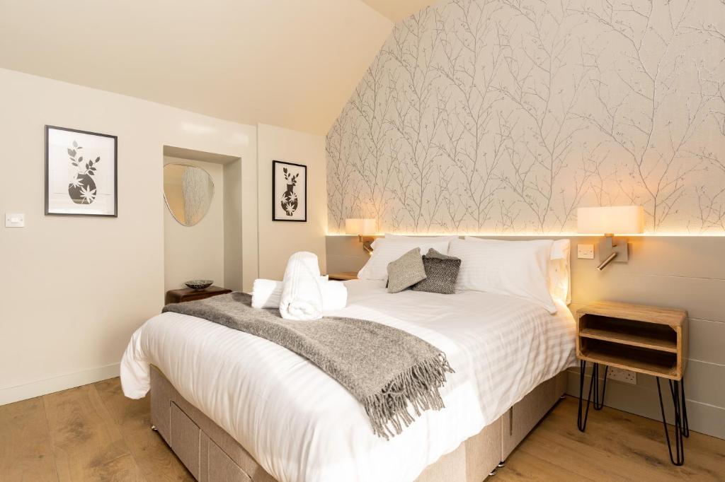 a bedroom with a large white bed with white sheets at The Roost on Rock Road in Barry