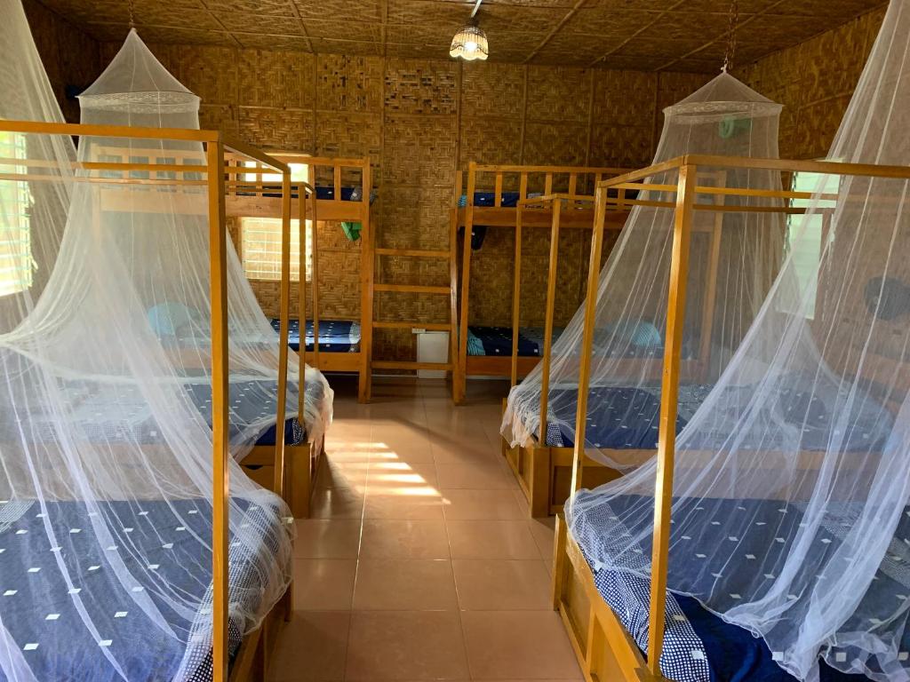 Cette chambre dispose de 3 lits superposés et de moustiquaires. dans l'établissement Izla Soanna, à Panglao